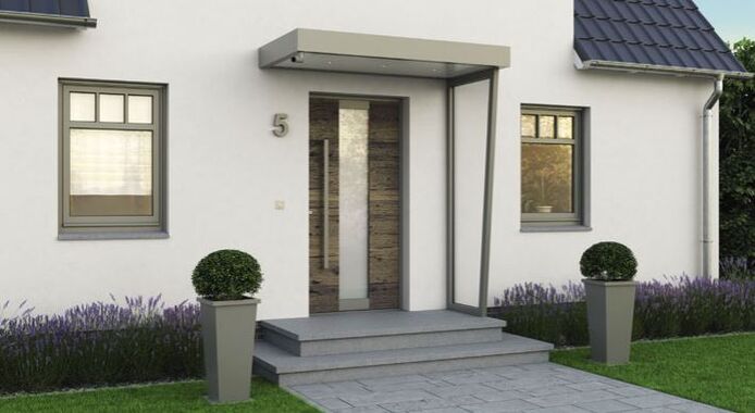 Kompotherm Aluminium Haustür mit schmalem Glas-Seitenteil und modernem Vordach am Hauseingang