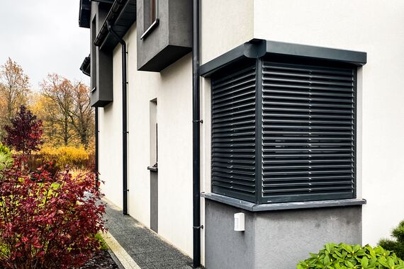 Solarrollladen in Anthrazit an weißem Haus mit Putzfassade