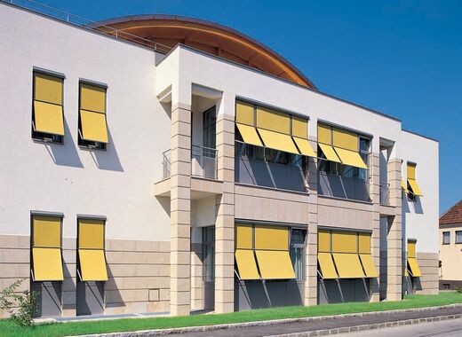 Sonnenschutz an modernem Haus mit gelben Fassaden-Markisen