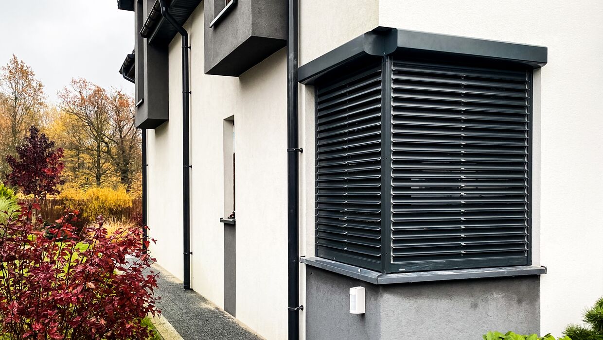 Solarrollladen in Anthrazit an weißem Haus mit Putzfassade